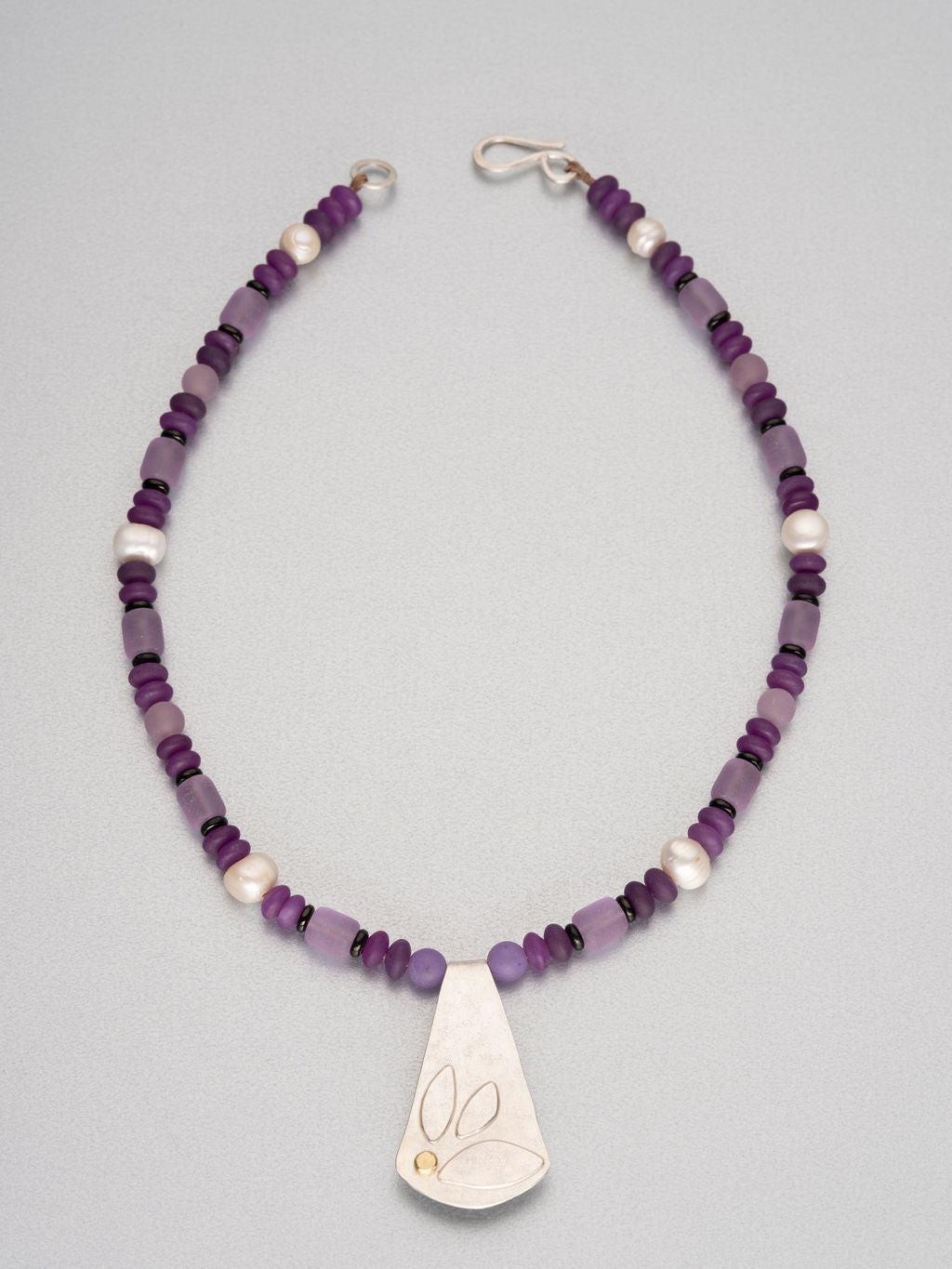 Beaded necklace with sea glass, semi-precious stones and a silver pendant with 18 ct gold detail.